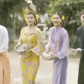 a group of people in traditional clothes are walking down a street .