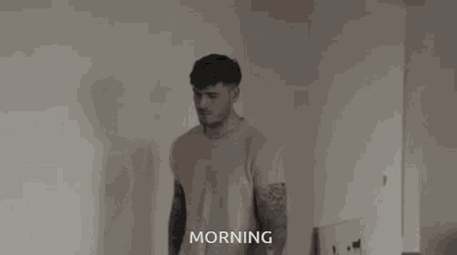 a man in a white shirt is standing in front of a mirror and the word morning is on the bottom