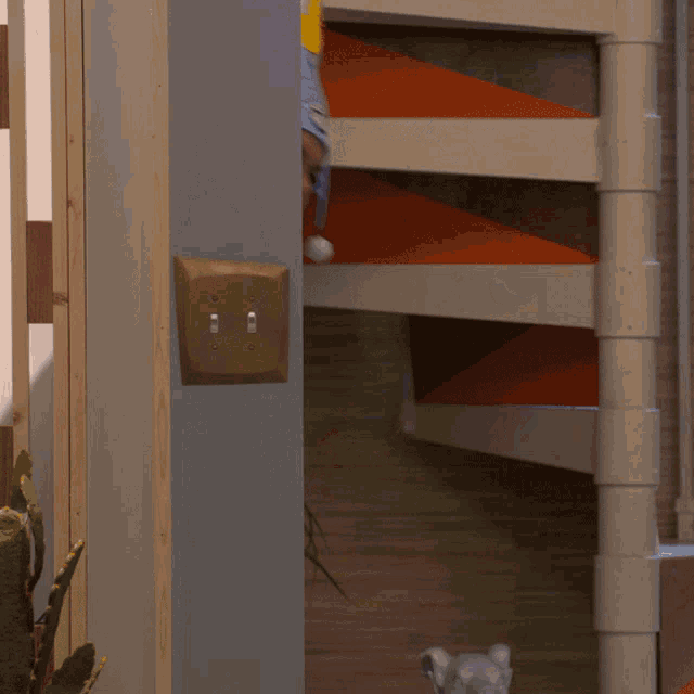 a man and a woman are peeking out from behind a door