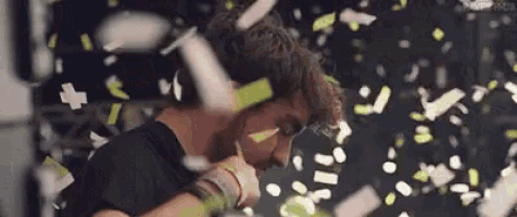 a man is standing in front of a crowd of confetti .