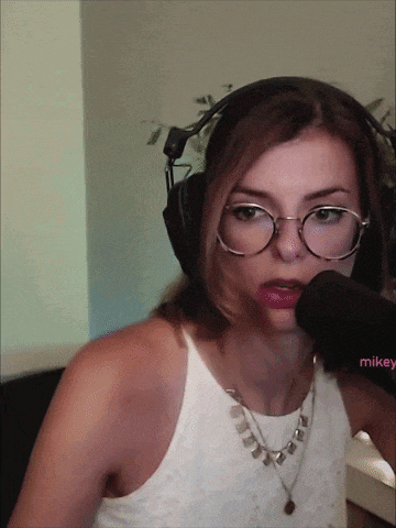 a woman wearing glasses and headphones is talking into a microphone with the name mikey on the bottom right