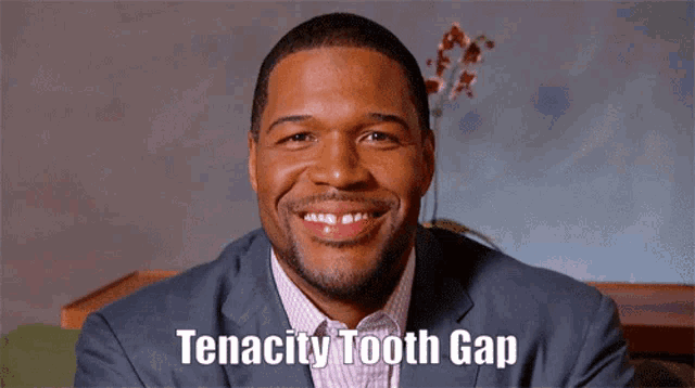 a man in a suit is smiling with the words tenacity tooth gap above him