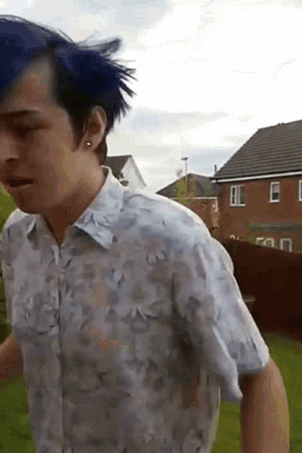 a man with blue hair wearing a floral shirt