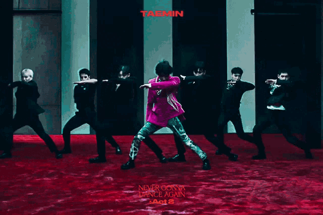 a group of men are dancing in front of a sign that says taemin on it