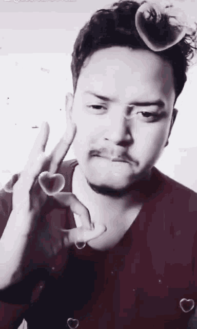 a man in a red shirt is making a peace sign with his hand