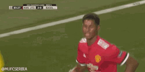 a man in a red and white jersey is running on a soccer field