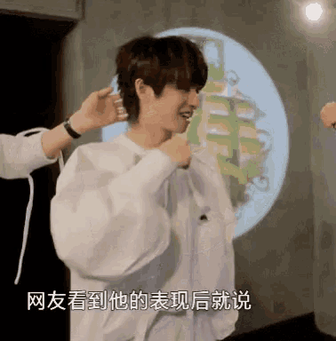 a man in a white shirt is getting his hair done