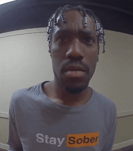 a man with dreadlocks wears a shirt that says stay sober
