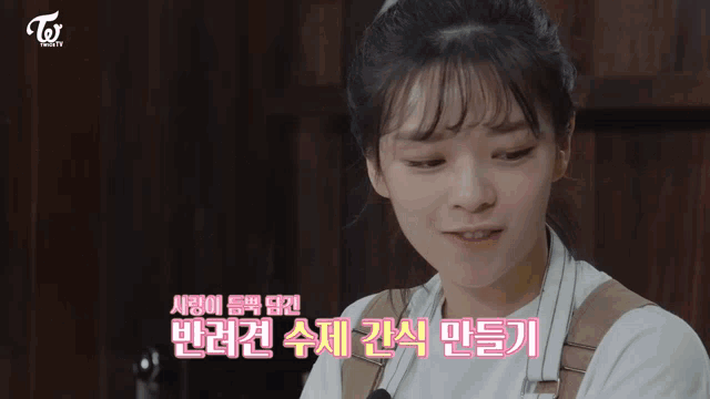 a woman in an apron is standing in a kitchen with korean writing on it