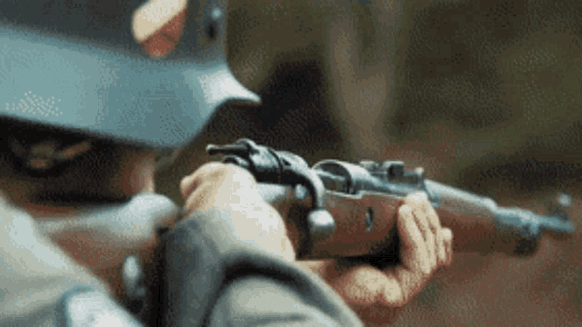a man in a helmet is pointing a gun