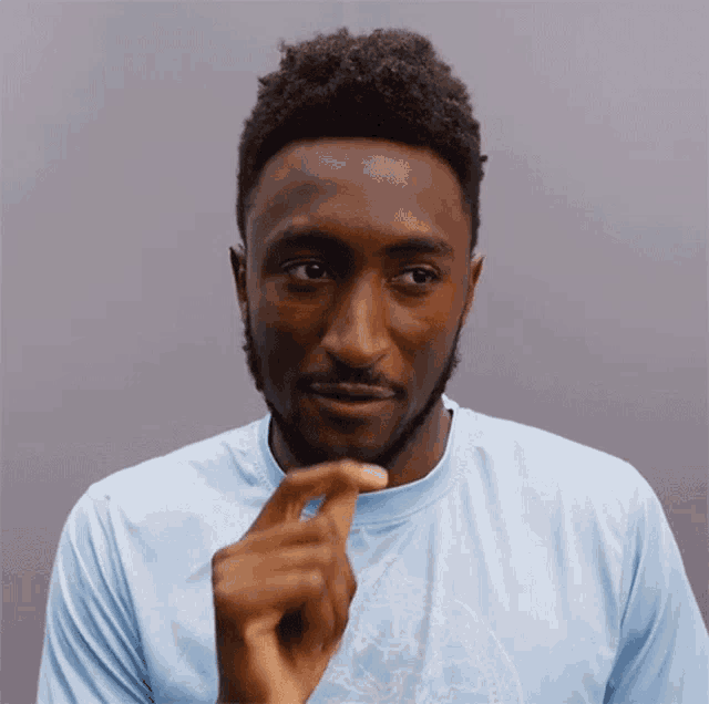 a man in a blue shirt is making a face