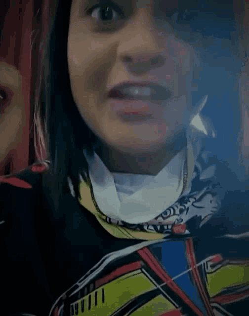 a woman wearing a wonder woman shirt looks at the camera with a surprised look on her face