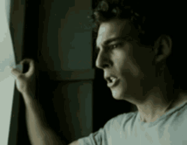 a man is looking out a window with his mouth open