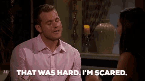 a man in a pink shirt is sitting at a table with a woman and saying that was hard .
