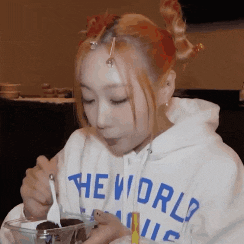 a girl wearing a white hoodie that says the world