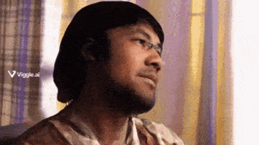 a man wearing glasses and a hat is sitting in front of a window with a viggle.ai logo behind him