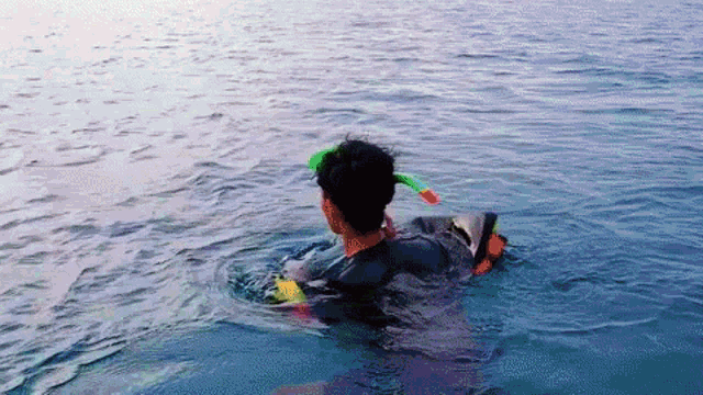a man in a wet suit is floating in the water