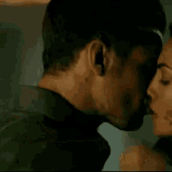 a man and a woman are hugging each other and the woman is holding the man 's head .