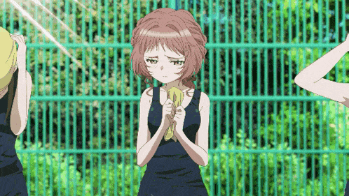 a girl in a tank top holds a banana in her hands