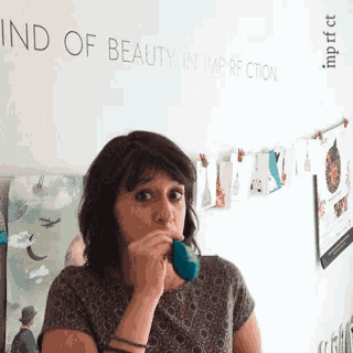 a woman in front of a wall that says kind of beauty in imperection
