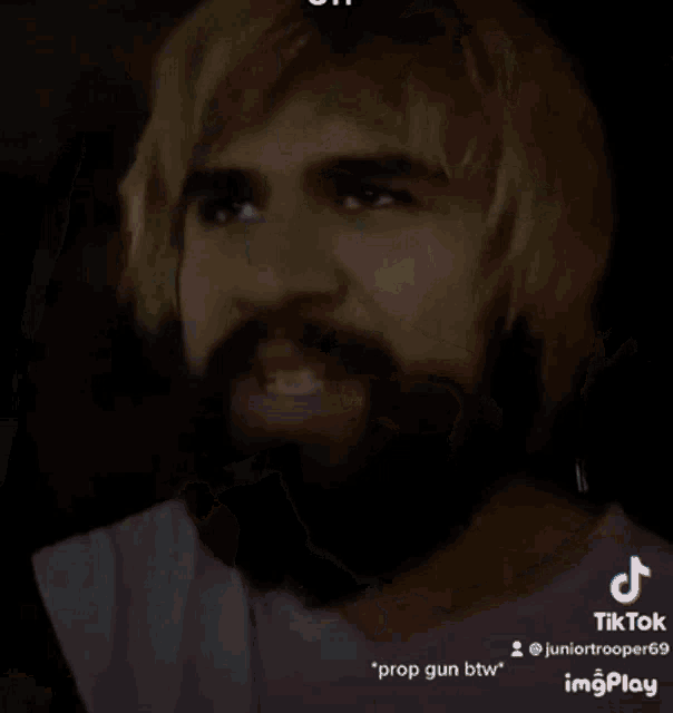 a man with blonde hair and a beard is sitting in a car with a caption that says prop gun btw