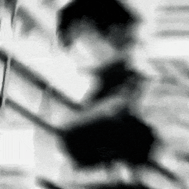a blurry black and white photo of a person holding a sword