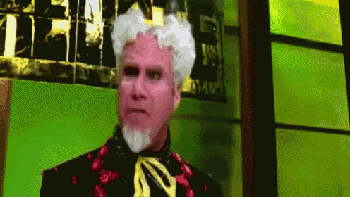 a man with white hair and a beard is wearing a black suit