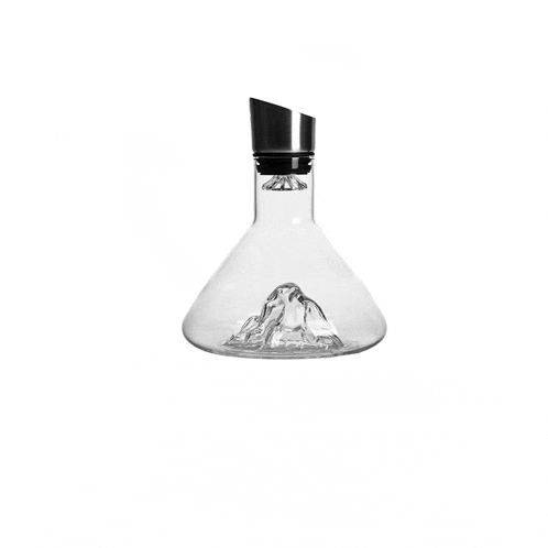 a clear glass decanter with a mountain on top