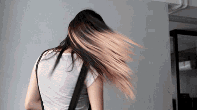 a woman with long hair is wearing a grey shirt