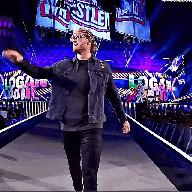a wrestler walks down a ramp with a sign that says logan