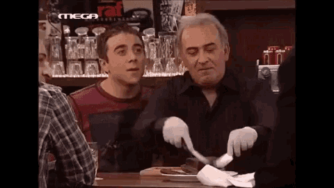 a man wearing white gloves is cutting a piece of meat in a restaurant