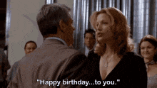 a man and a woman are standing next to each other and the woman is saying happy birthday to you
