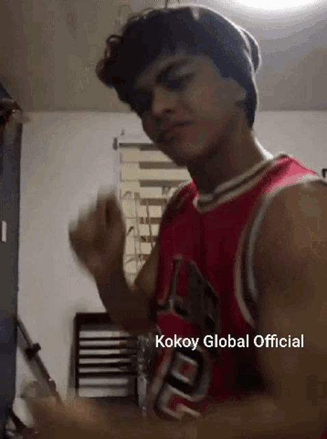 a young man wearing a red chicago bulls jersey is dancing