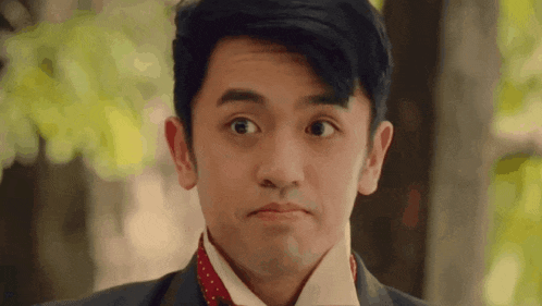 a man in a suit and tie is making a face .