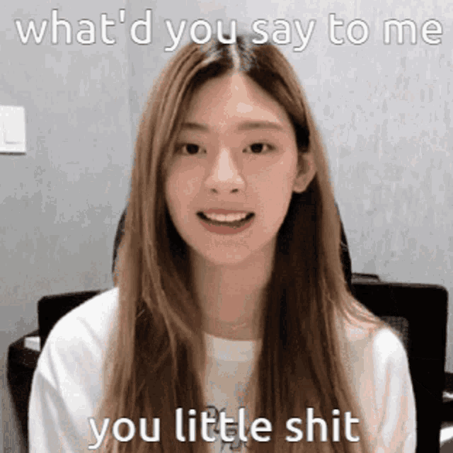 a girl with long hair is smiling and says " what 'd you say to me you little shit "