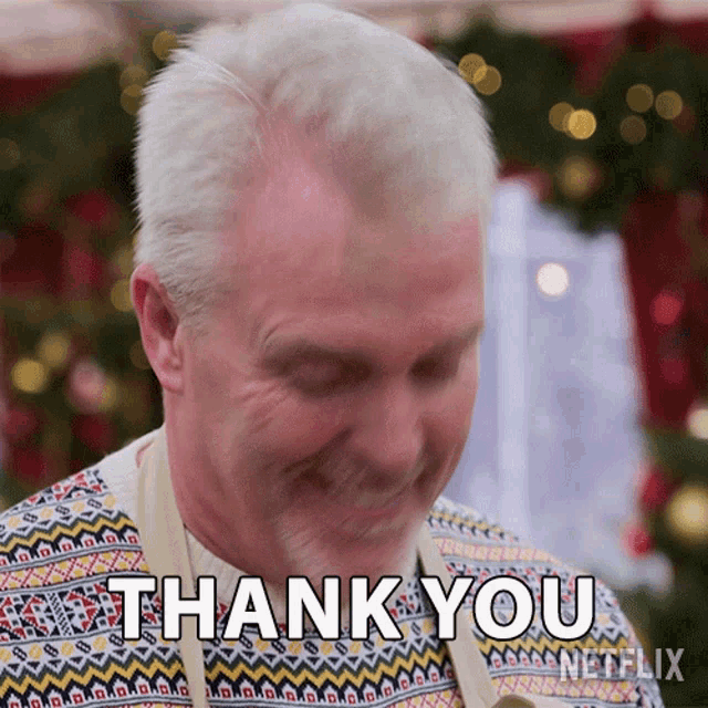 a man in a sweater is smiling and saying " thank you "