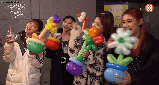 a group of women are posing for a picture with balloons and flowers