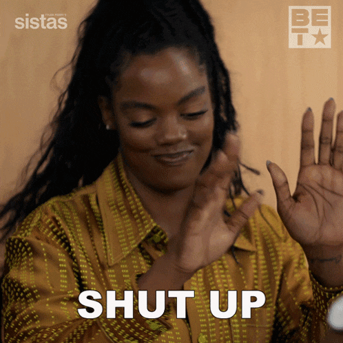 a woman in a yellow shirt is making a shut up gesture