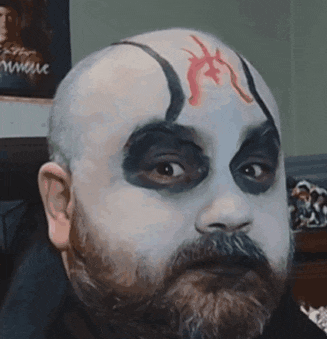a bald man with a beard has his face painted to look like a demon