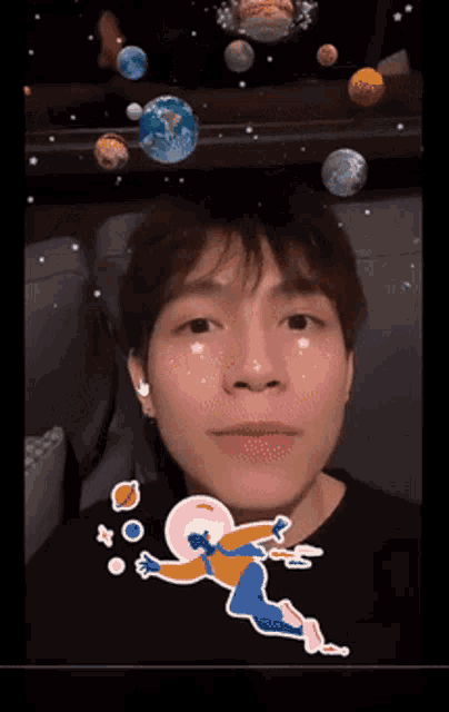 a young man is wearing a black shirt with a drawing of an astronaut on it