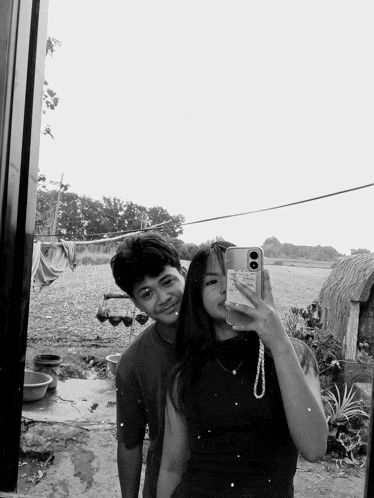 a man and a woman are taking a selfie in front of a mirror with a phone case that says i love you on it