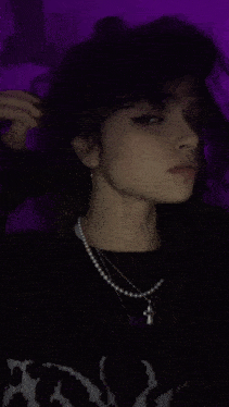 a woman with a nose ring and a necklace is giving the middle finger .