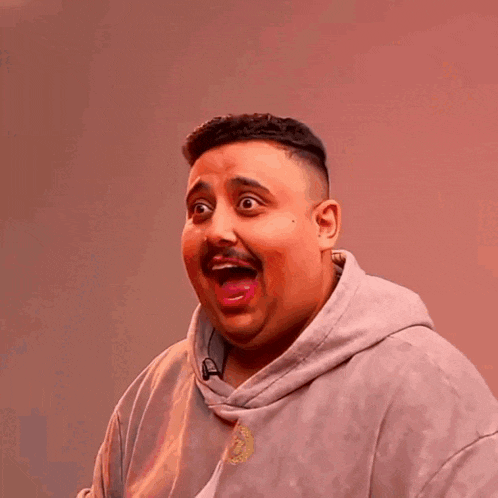 a man wearing a gray hoodie with a picture of a man on it