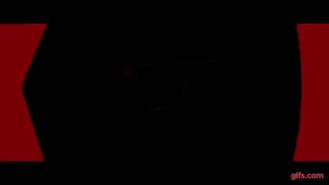 a person is walking down a hallway with red lights on the walls .
