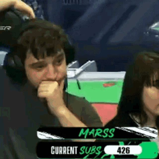 a man and a woman are sitting in front of a screen that says marss current subs 427 .