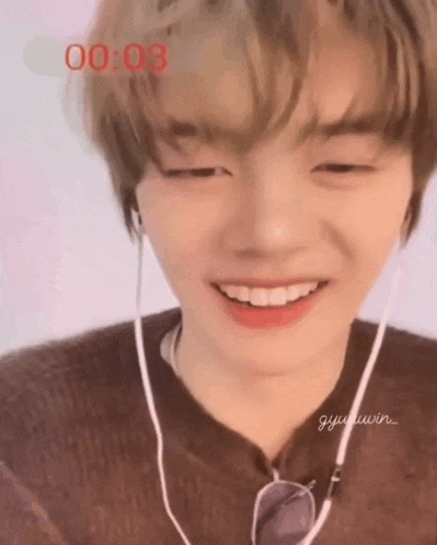 a close up of a young man wearing headphones and smiling .