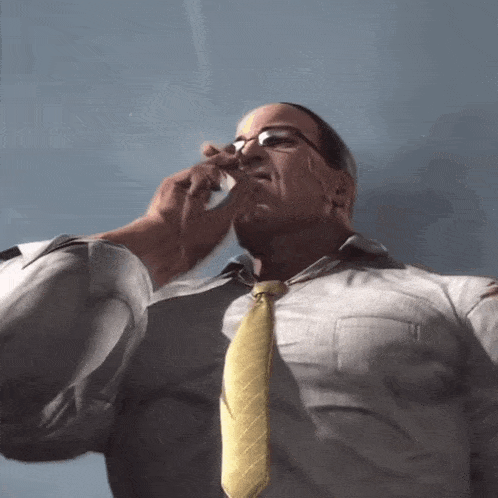 a man with glasses and a yellow tie wipes his nose with a tissue