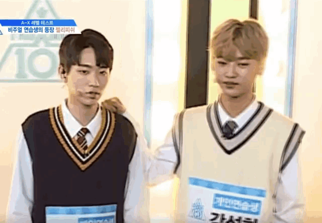 two boys are standing next to each other and one has a card that says a-x