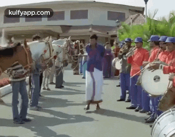 a man is dancing in front of a band of men playing drums and horses .