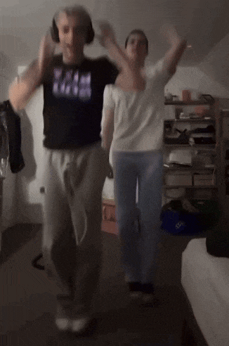 a man wearing headphones is dancing with a woman